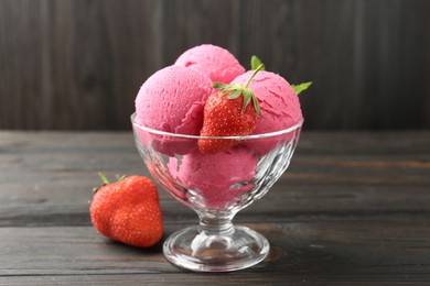 Photo of Tasty sorbet with strawberries and mint served on wooden table, closeup