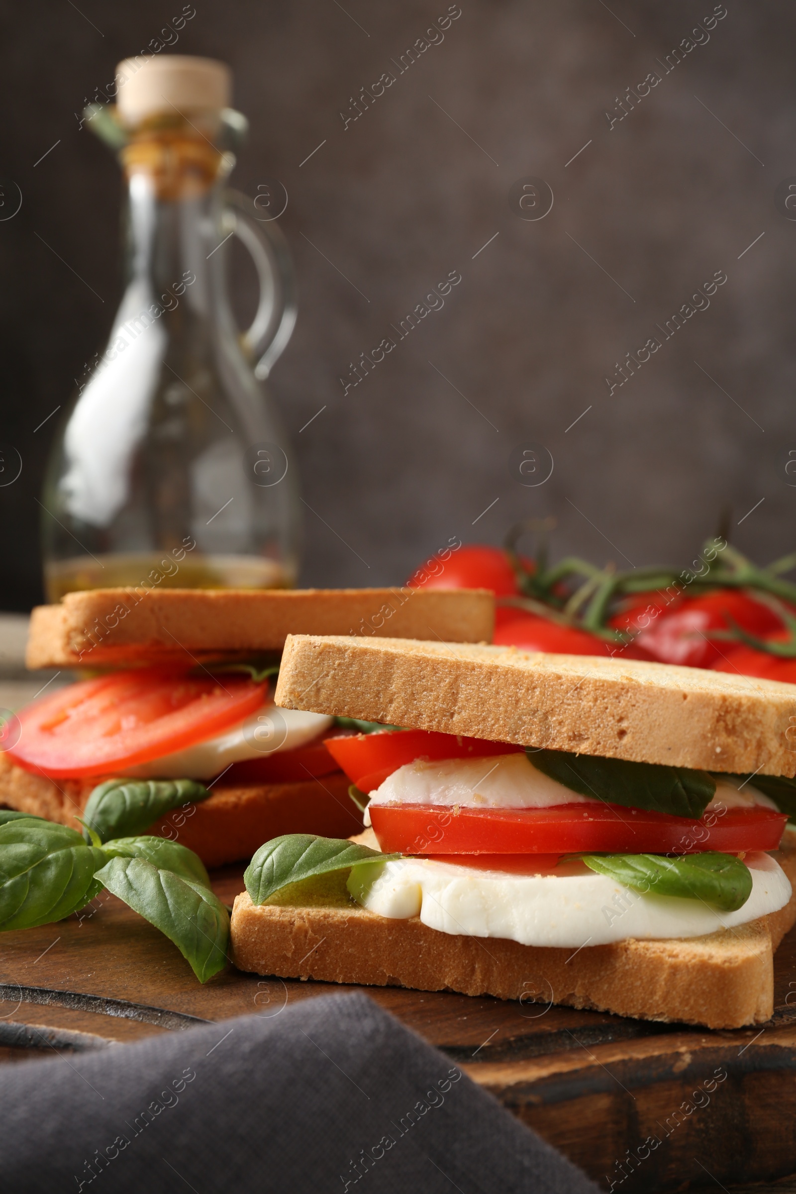 Tasty sandwiches with mozzarella cheese, tomatoes and basil on table, closeup Photo of Tasty sandwiches with mozzarella cheese, tomatoes and basil on table, closeup