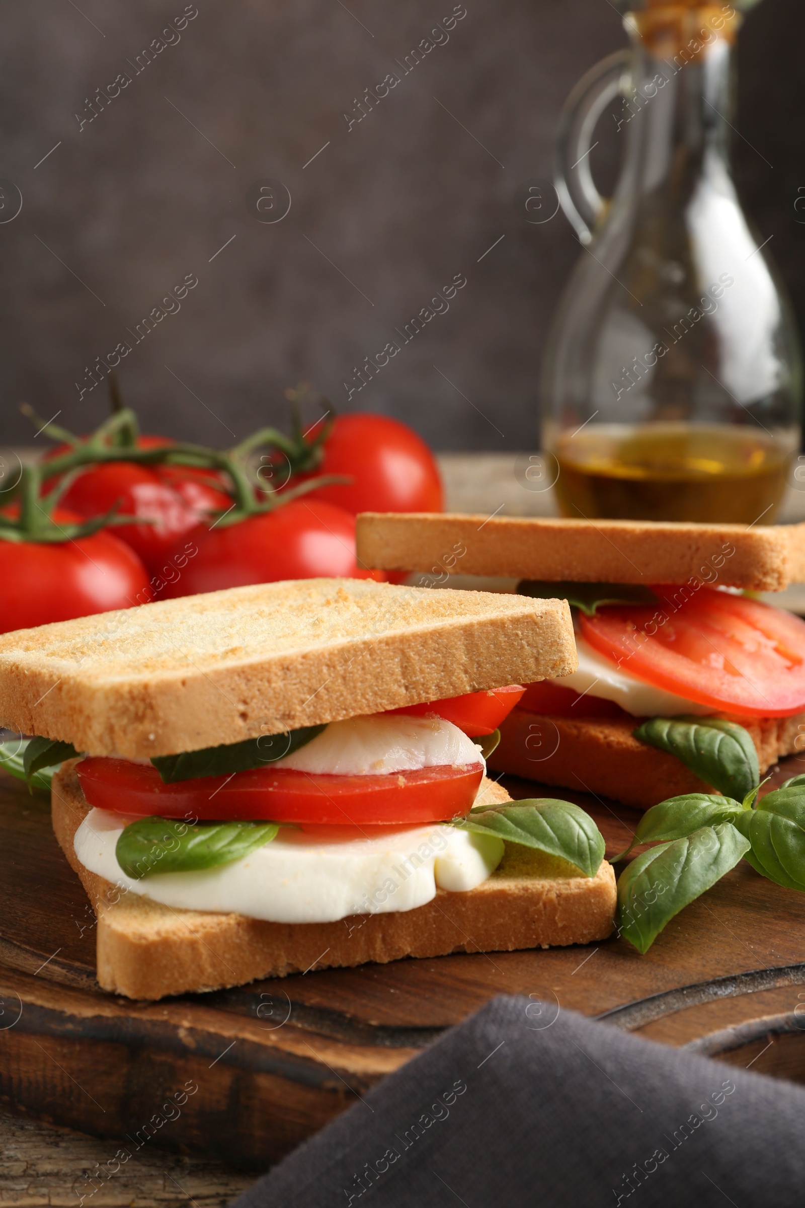 Tasty sandwiches with mozzarella cheese, tomatoes and basil on table, closeup Photo of Tasty sandwiches with mozzarella cheese, tomatoes and basil on table, closeup