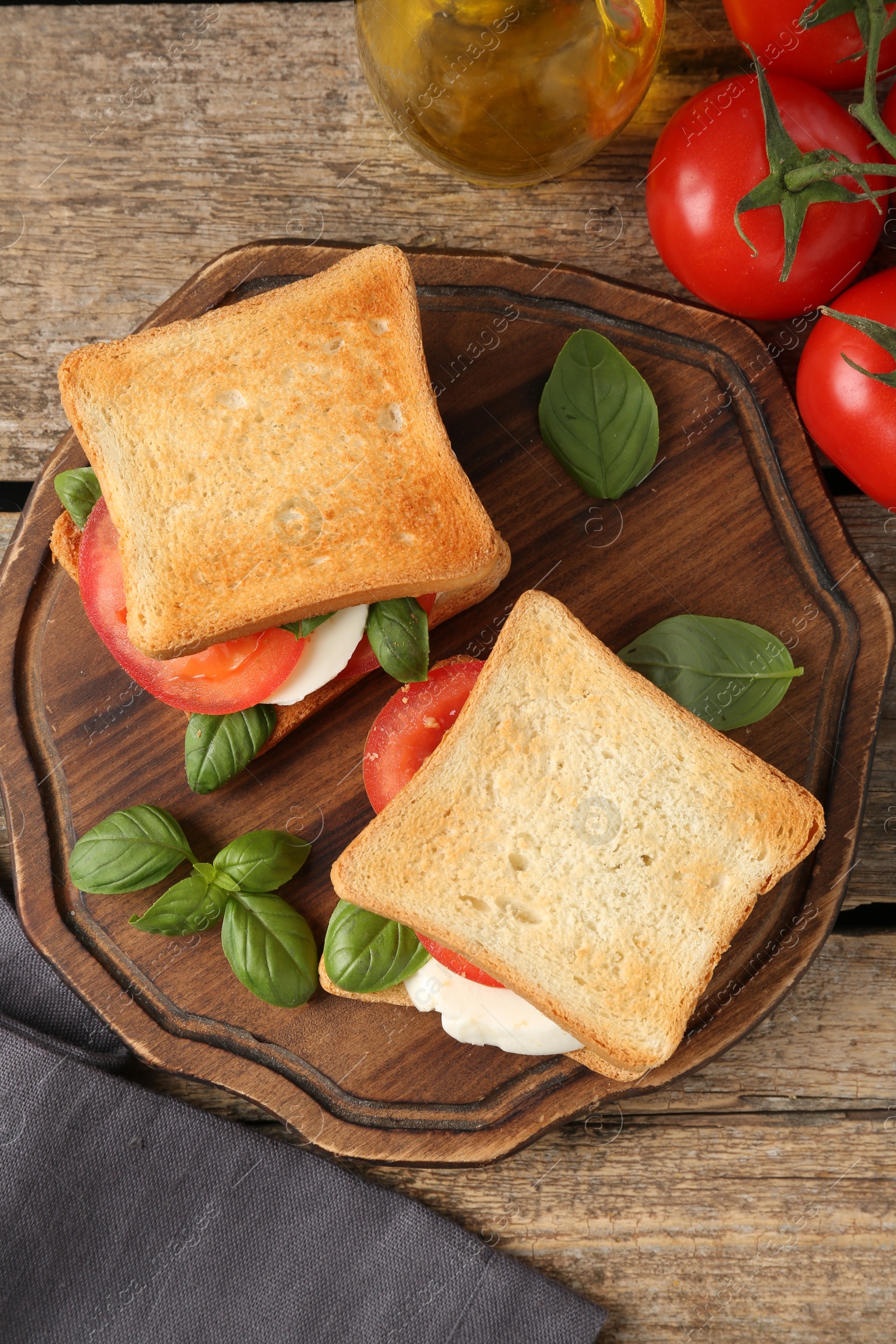 Tasty sandwiches with mozzarella cheese, tomatoes and basil on wooden table, flat lay Photo of Tasty sandwiches with mozzarella cheese, tomatoes and basil on wooden table, flat lay