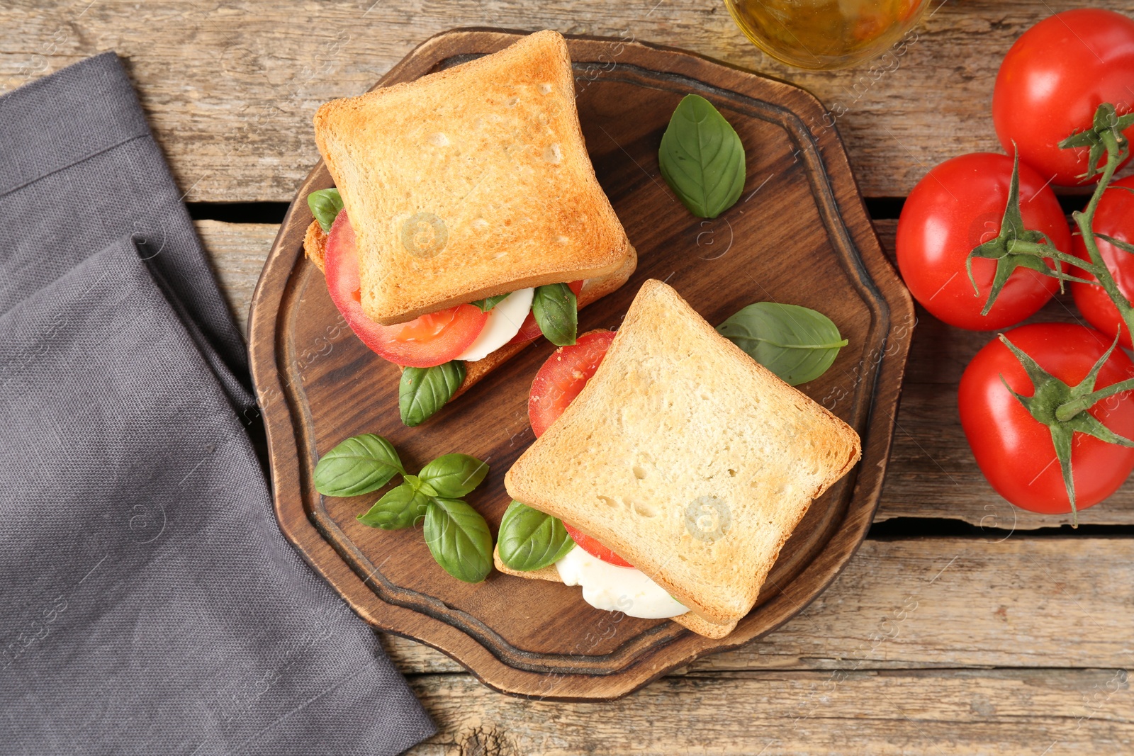 Tasty sandwiches with mozzarella cheese, tomatoes and basil on wooden table, flat lay Photo of Tasty sandwiches with mozzarella cheese, tomatoes and basil on wooden table, flat lay