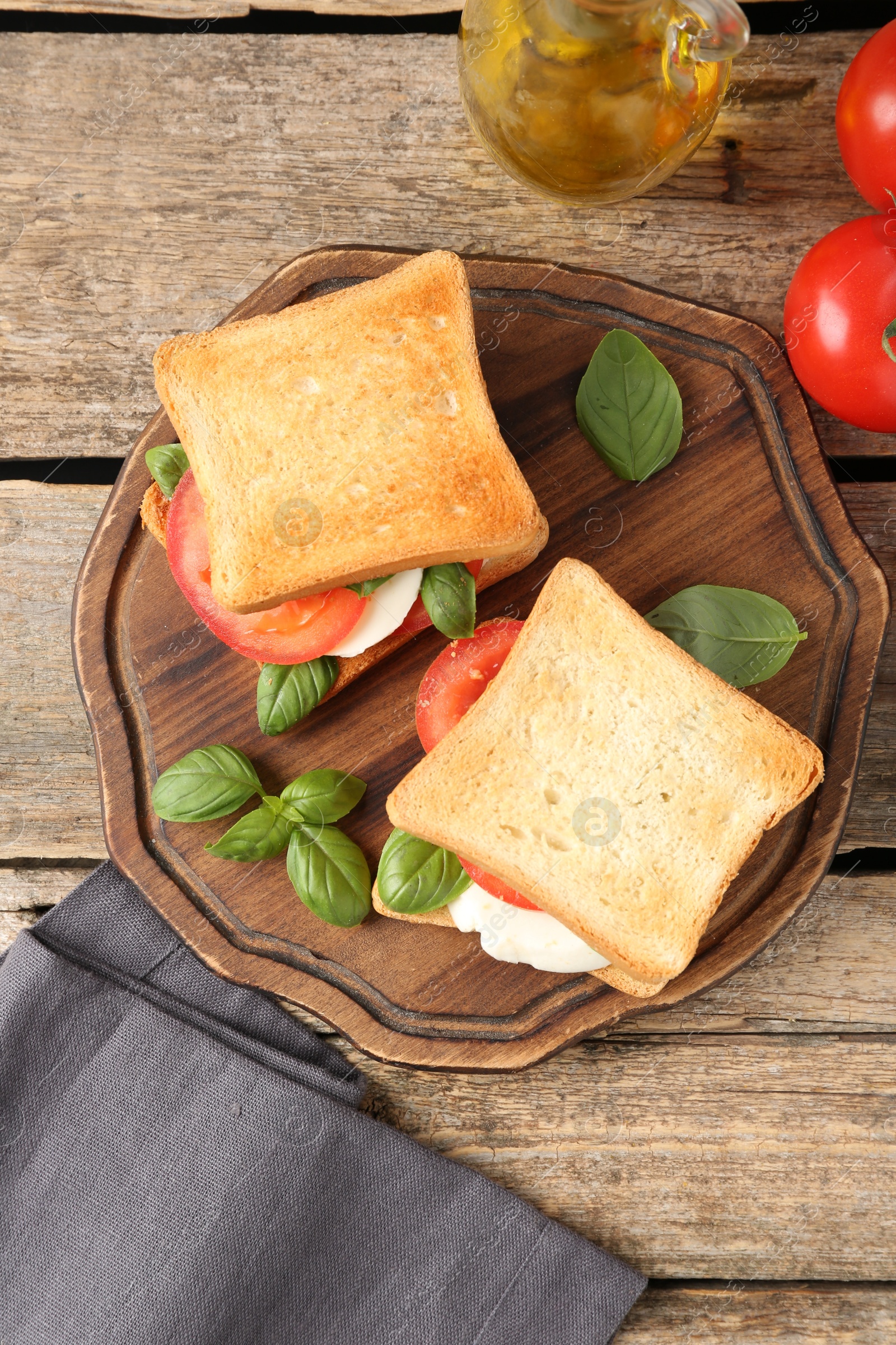 Tasty sandwiches with mozzarella cheese, tomatoes and basil on wooden table, flat lay Photo of Tasty sandwiches with mozzarella cheese, tomatoes and basil on wooden table, flat lay