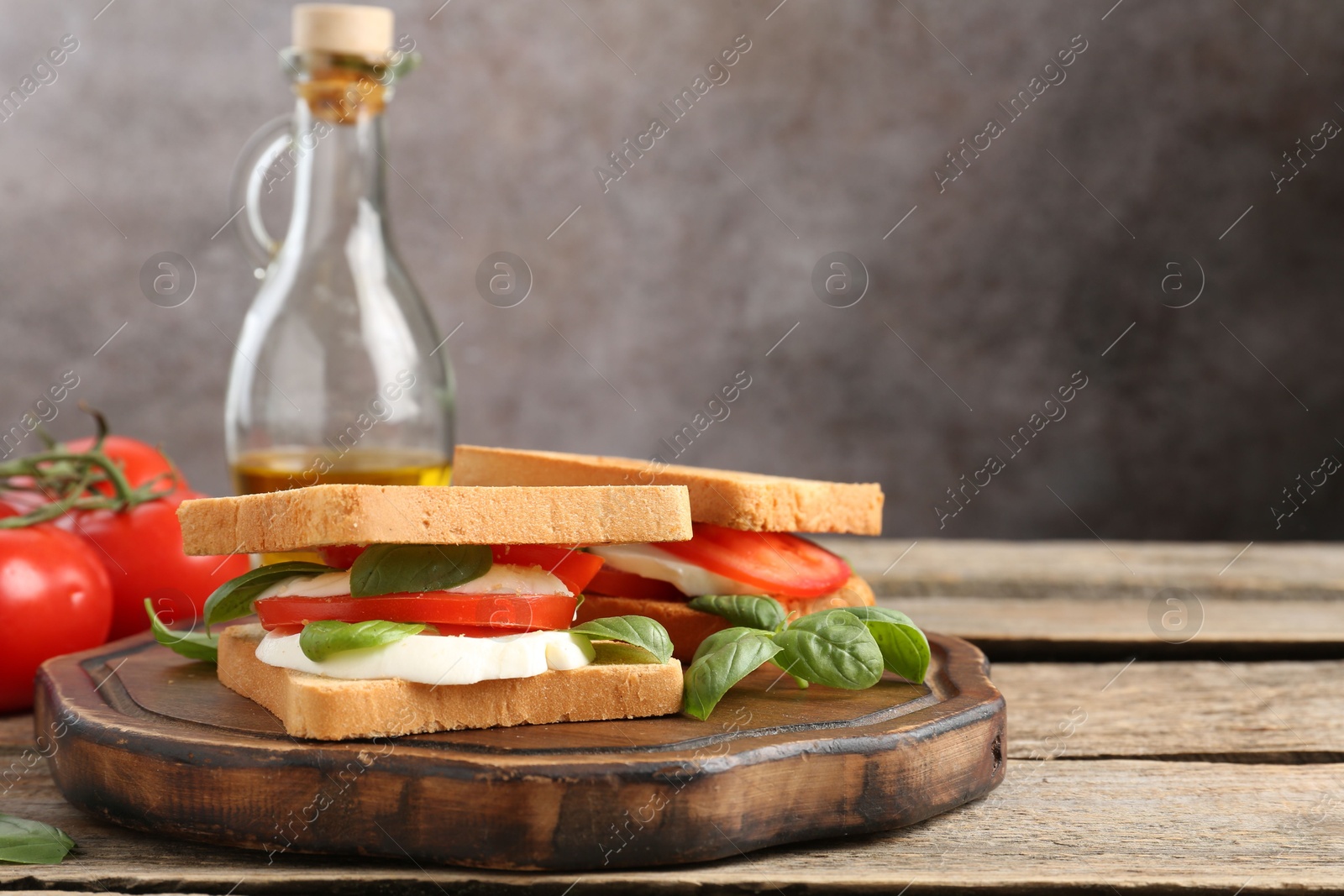 Tasty sandwiches with mozzarella cheese, tomatoes and basil on wooden table, closeup. Space for text Photo of Tasty sandwiches with mozzarella cheese, tomatoes and basil on wooden table, closeup. Space for text
