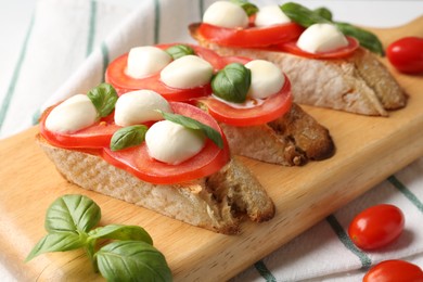 Photo of Tasty sandwiches with mozzarella cheese, tomatoes and basil on table, closeup