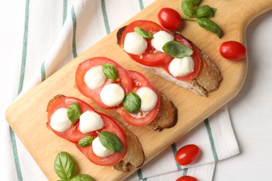 Photo of Tasty sandwiches with mozzarella cheese, tomatoes and basil on white table, top view
