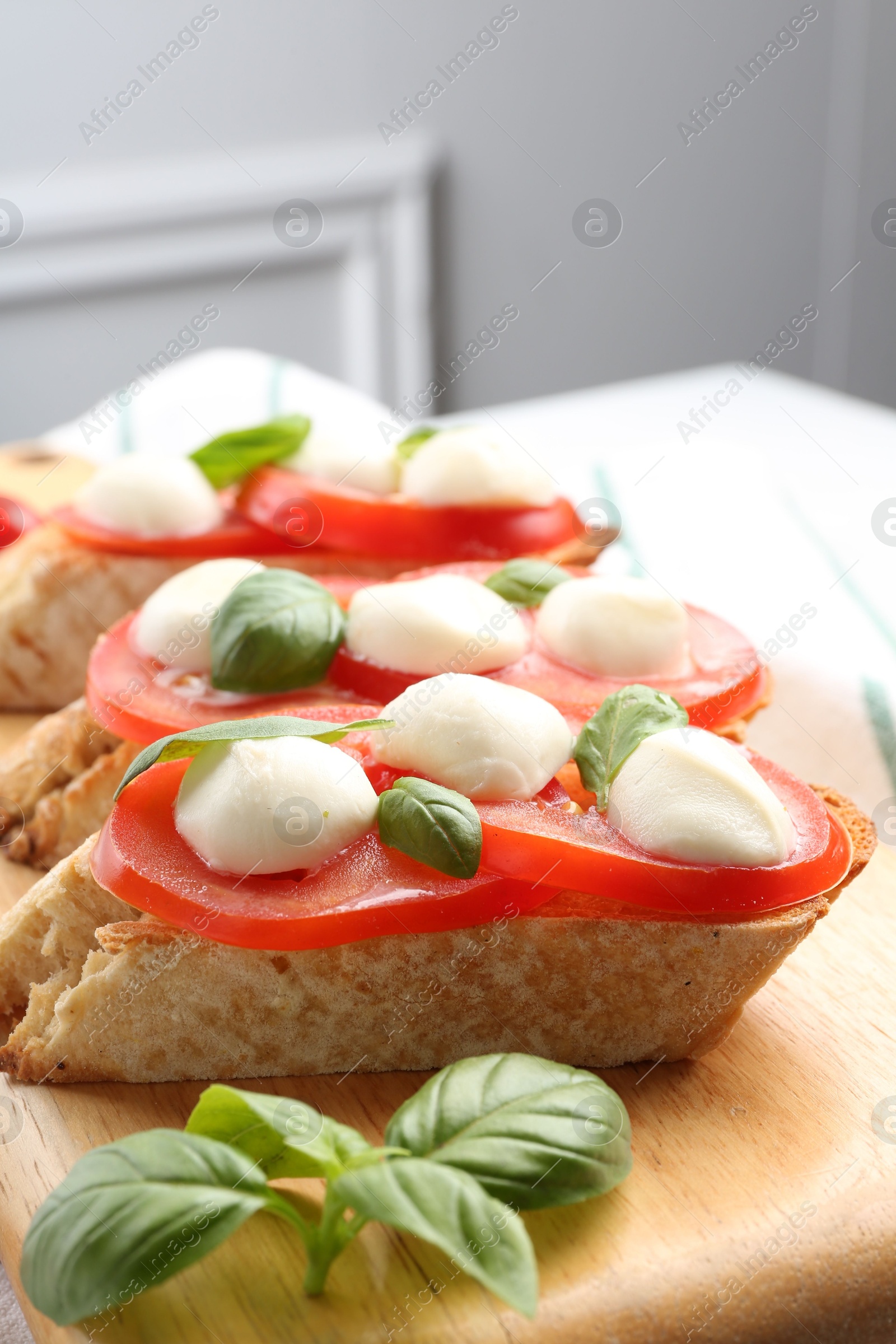 Tasty sandwiches with mozzarella cheese, tomatoes and basil on table, closeup Photo of Tasty sandwiches with mozzarella cheese, tomatoes and basil on table, closeup