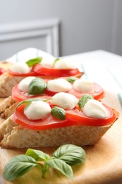 Photo of Tasty sandwiches with mozzarella cheese, tomatoes and basil on table, closeup