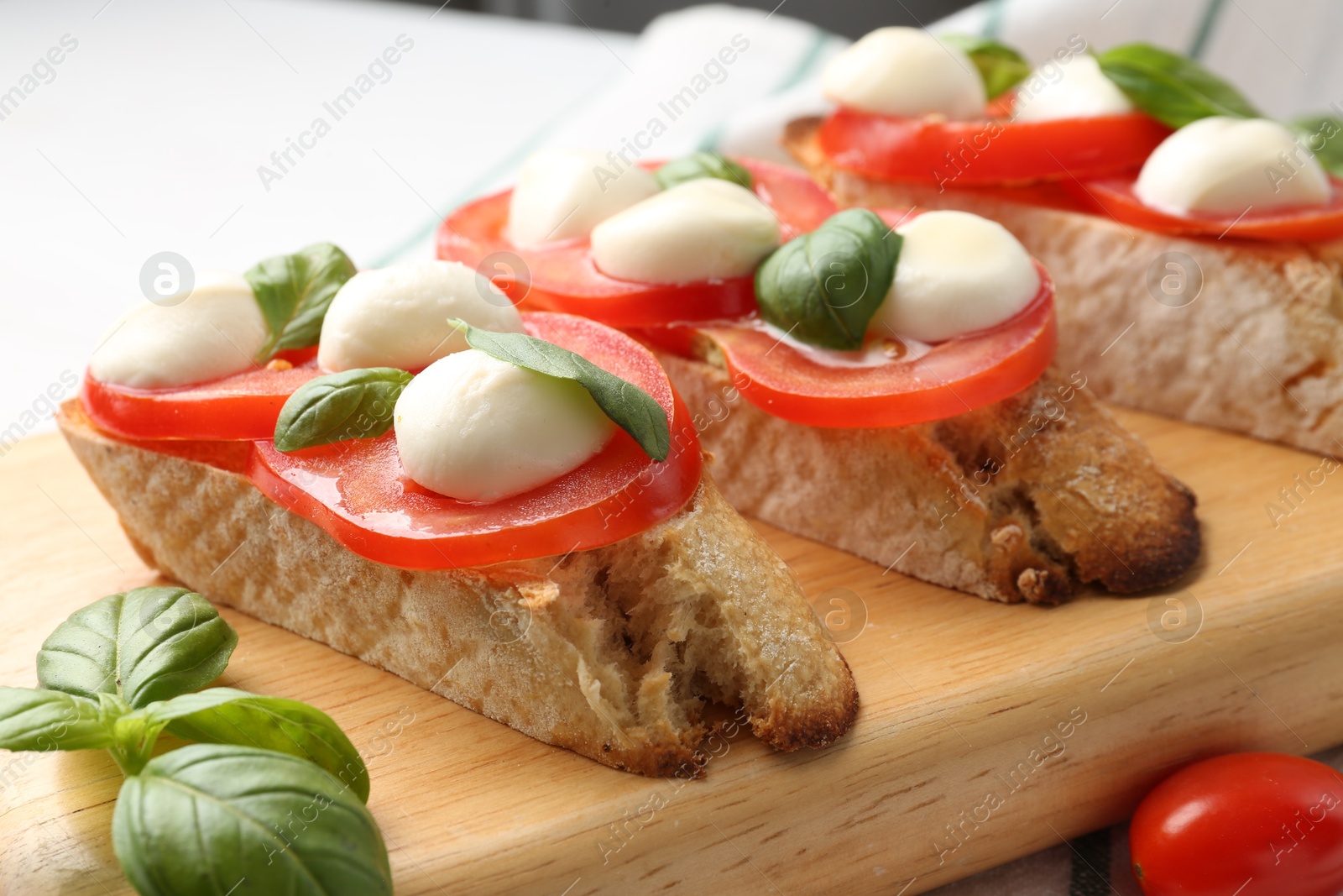 Tasty sandwiches with mozzarella cheese, tomatoes and basil on table, closeup Photo of Tasty sandwiches with mozzarella cheese, tomatoes and basil on table, closeup