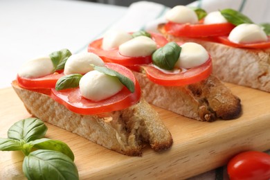 Photo of Tasty sandwiches with mozzarella cheese, tomatoes and basil on table, closeup