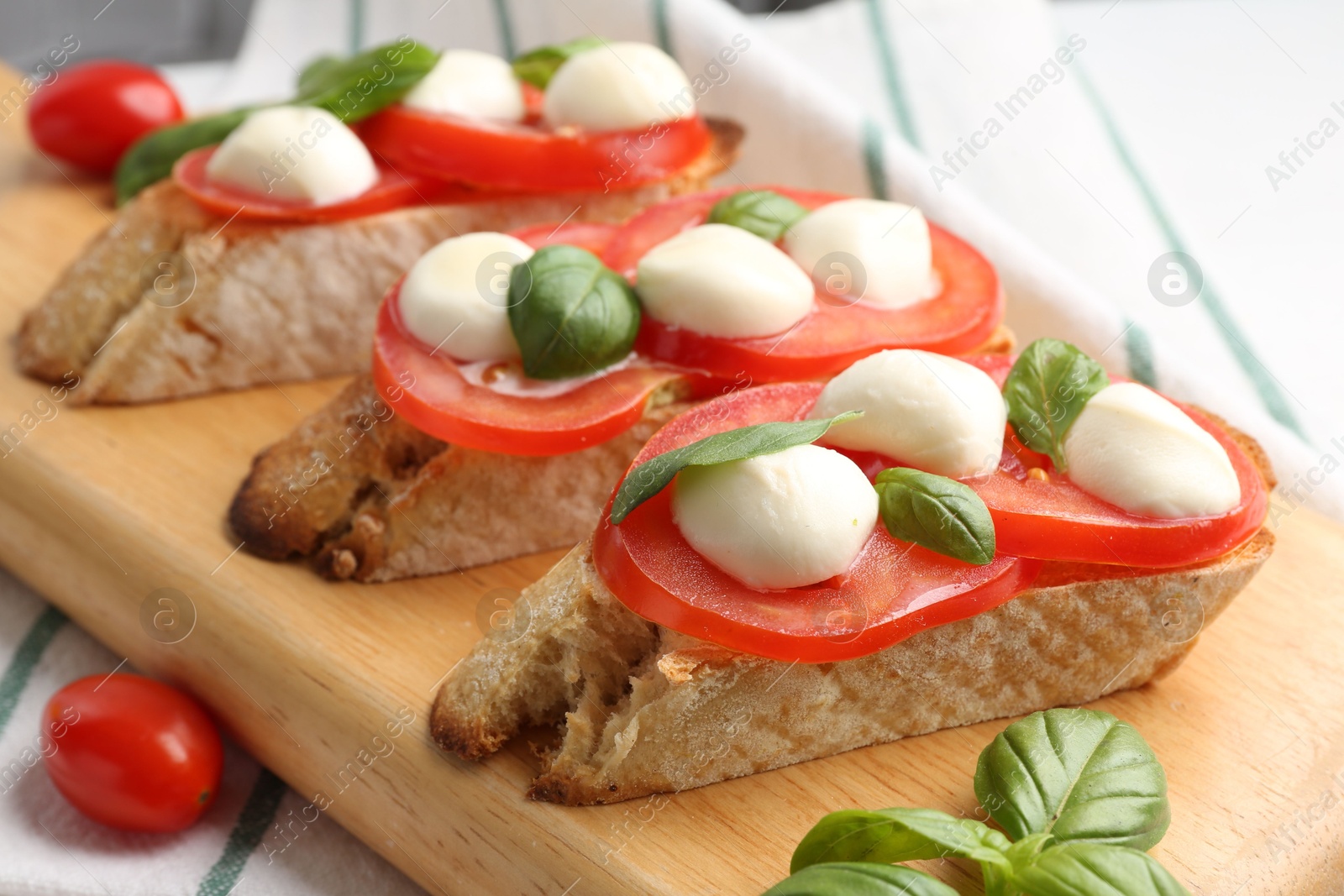 Tasty sandwiches with mozzarella cheese, tomatoes and basil on table, closeup Photo of Tasty sandwiches with mozzarella cheese, tomatoes and basil on table, closeup