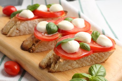 Photo of Tasty sandwiches with mozzarella cheese, tomatoes and basil on table, closeup