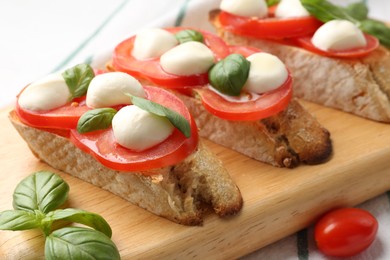 Photo of Tasty sandwiches with mozzarella cheese, tomatoes and basil on table, closeup