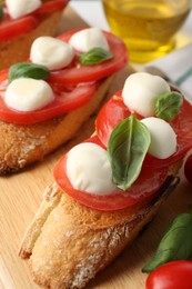 Photo of Tasty sandwiches with mozzarella cheese, tomatoes and basil on table, closeup