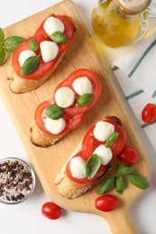 Photo of Tasty sandwiches with mozzarella cheese, tomatoes and basil on white table, flat lay