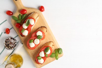 Photo of Tasty sandwiches with mozzarella cheese, tomatoes and basil on white table, flat lay. Space for text