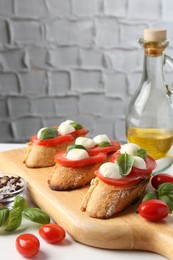 Photo of Tasty sandwiches with mozzarella cheese, tomatoes and basil on white table, closeup