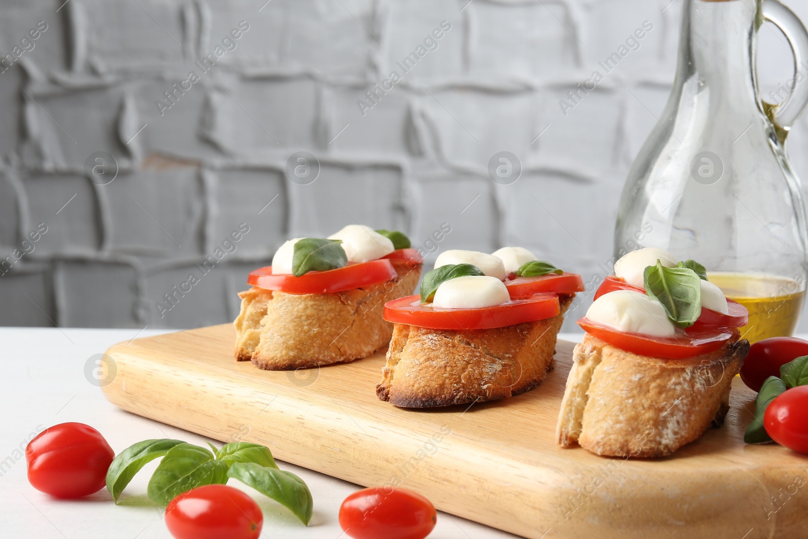 Tasty sandwiches with mozzarella cheese, tomatoes and basil on white table, closeup. Space for text Photo of Tasty sandwiches with mozzarella cheese, tomatoes and basil on white table, closeup. Space for text