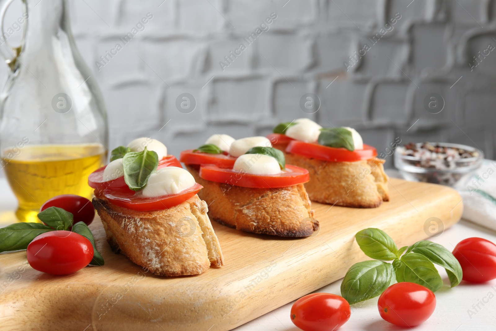 Tasty sandwiches with mozzarella cheese, tomatoes and basil on white table, closeup Photo of Tasty sandwiches with mozzarella cheese, tomatoes and basil on white table, closeup