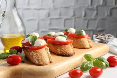 Photo of Tasty sandwiches with mozzarella cheese, tomatoes and basil on white table, closeup
