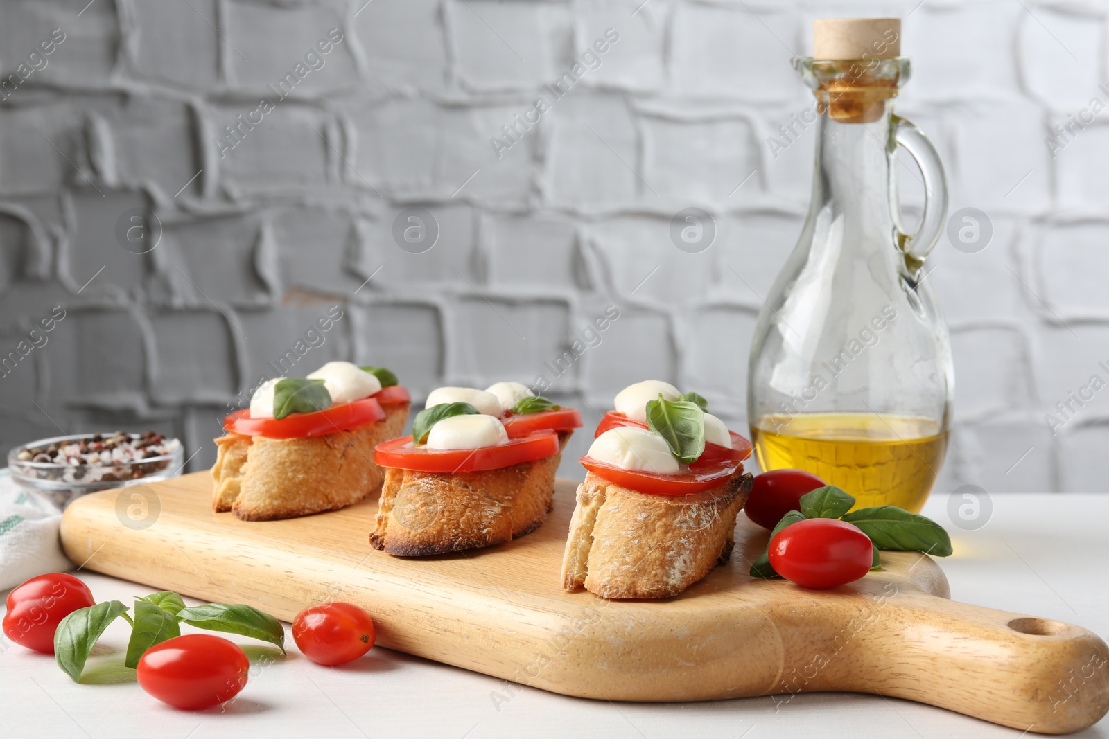 Tasty sandwiches with mozzarella cheese, tomatoes and basil on white table, closeup Photo of Tasty sandwiches with mozzarella cheese, tomatoes and basil on white table, closeup