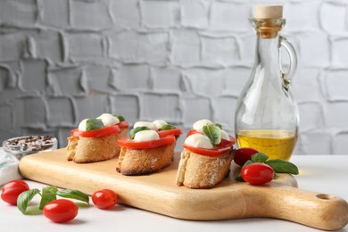 Photo of Tasty sandwiches with mozzarella cheese, tomatoes and basil on white table, closeup