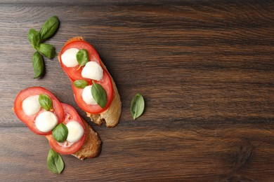 Photo of Tasty sandwiches with mozzarella cheese, tomatoes and basil on wooden table, flat lay. Space for text