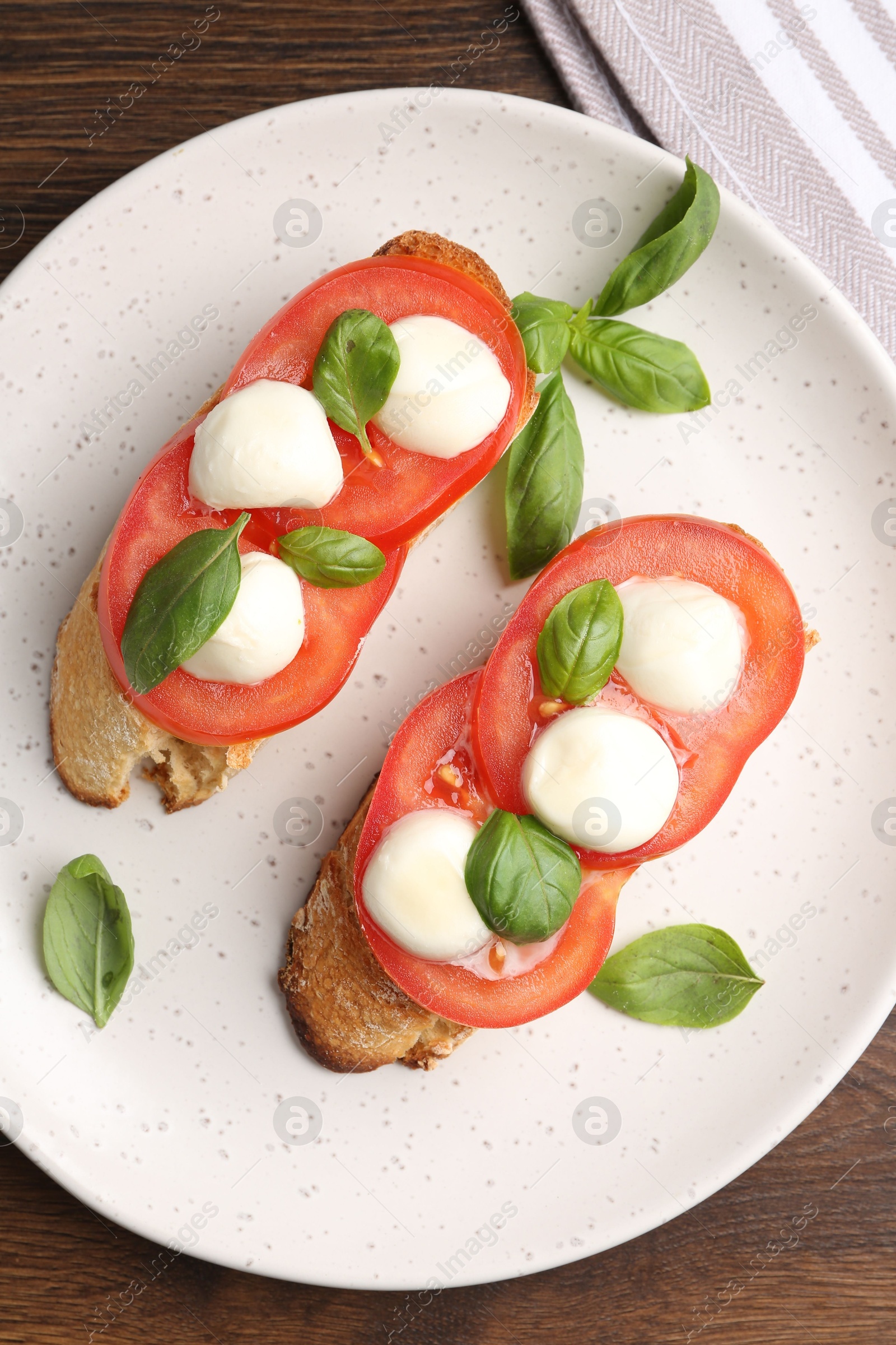 Tasty sandwiches with mozzarella cheese, tomatoes and basil on wooden table, top view Photo of Tasty sandwiches with mozzarella cheese, tomatoes and basil on wooden table, top view