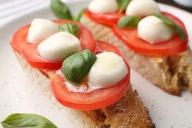 Photo of Tasty sandwiches with mozzarella cheese, tomatoes and basil on plate, closeup