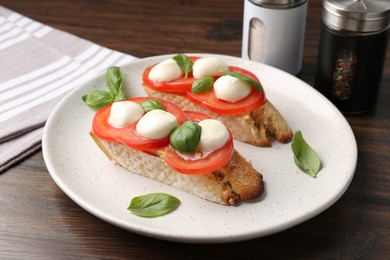 Photo of Tasty sandwiches with mozzarella cheese, tomatoes and basil on wooden table, closeup