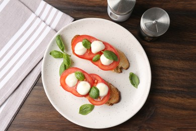 Photo of Tasty sandwiches with mozzarella cheese, tomatoes and basil on wooden table, flat lay