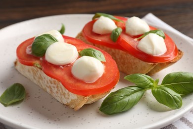 Photo of Tasty sandwiches with mozzarella cheese, tomatoes and basil on table, closeup