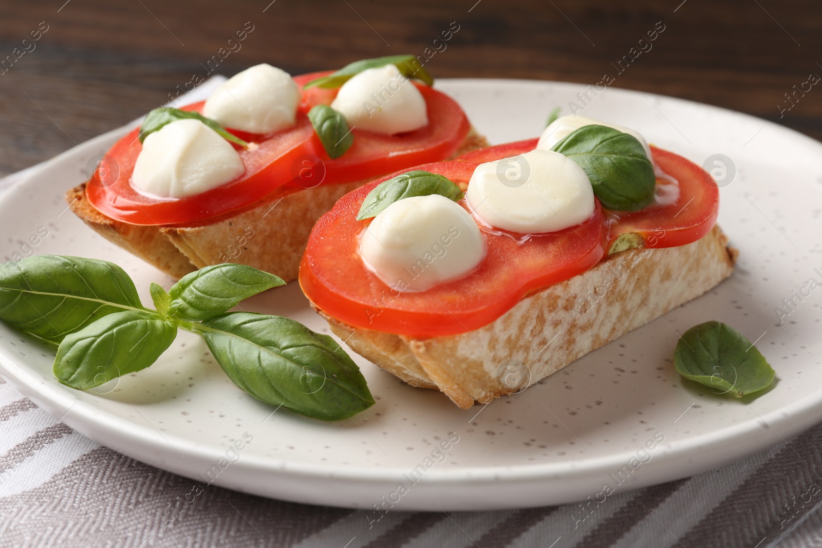 Tasty sandwiches with mozzarella cheese, tomatoes and basil on table, closeup Photo of Tasty sandwiches with mozzarella cheese, tomatoes and basil on table, closeup