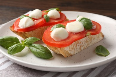 Photo of Tasty sandwiches with mozzarella cheese, tomatoes and basil on table, closeup