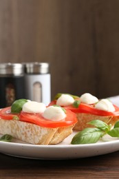 Photo of Tasty sandwiches with mozzarella cheese, tomatoes and basil on wooden table, closeup