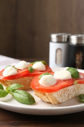 Photo of Tasty sandwiches with mozzarella cheese, tomatoes and basil on table, closeup