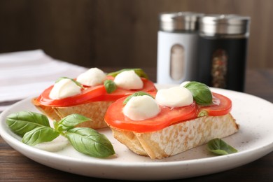 Photo of Tasty sandwiches with mozzarella cheese, tomatoes and basil on table, closeup