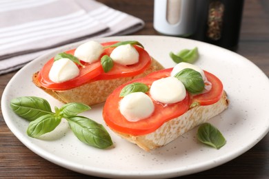 Photo of Tasty sandwiches with mozzarella cheese, tomatoes and basil on table, closeup