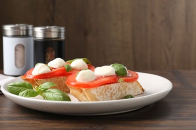 Photo of Tasty sandwiches with mozzarella cheese, tomatoes and basil on wooden table, closeup. Space for text