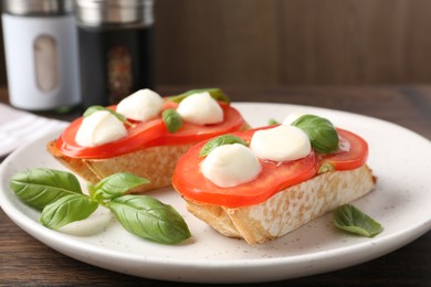 Photo of Tasty sandwiches with mozzarella cheese, tomatoes and basil on wooden table, closeup