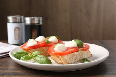 Photo of Tasty sandwiches with mozzarella cheese, tomatoes and basil on wooden table, closeup