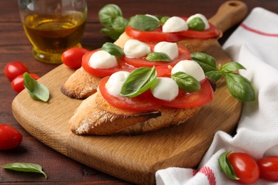 Photo of Tasty sandwiches with mozzarella cheese, tomatoes and basil on wooden table, closeup