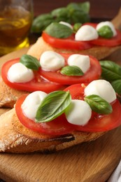 Photo of Tasty sandwiches with mozzarella cheese, tomatoes and basil on table, closeup