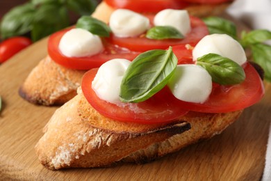 Photo of Tasty sandwiches with mozzarella cheese, tomatoes and basil on table, closeup