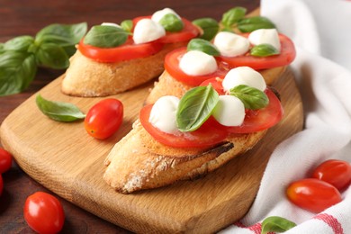 Photo of Tasty sandwiches with mozzarella cheese, tomatoes and basil on wooden table, closeup