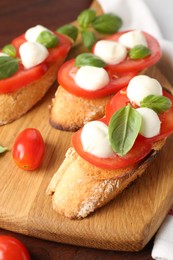 Photo of Tasty sandwiches with mozzarella cheese, tomatoes and basil on table, closeup