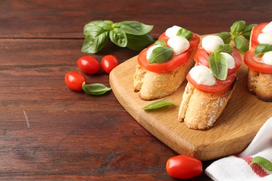 Photo of Tasty sandwiches with mozzarella cheese, tomatoes and basil on wooden table, closeup. Space for text
