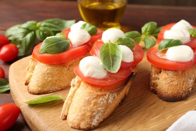 Photo of Tasty sandwiches with mozzarella cheese, tomatoes and basil on table, closeup