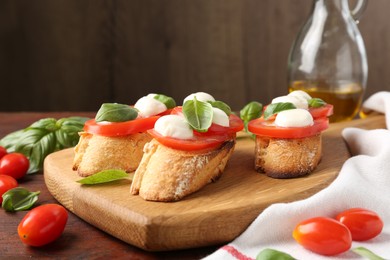 Photo of Tasty sandwiches with mozzarella cheese, tomatoes and basil on wooden table, closeup
