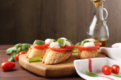 Photo of Tasty sandwiches with mozzarella cheese, tomatoes and basil on wooden table, closeup