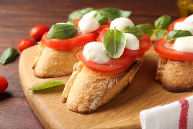 Photo of Tasty sandwiches with mozzarella cheese, tomatoes and basil on wooden table, closeup